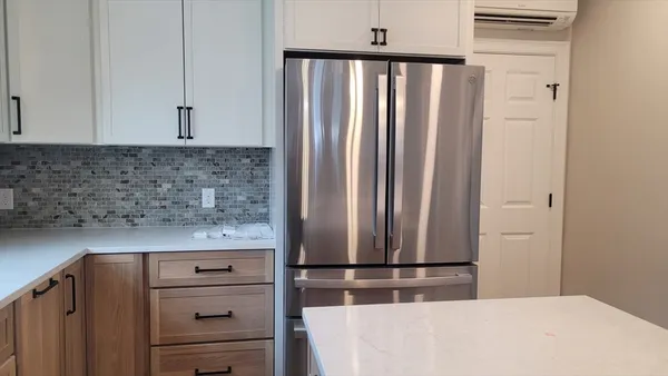 a kitchen with granite countertop a refrigerator sink and cabinets