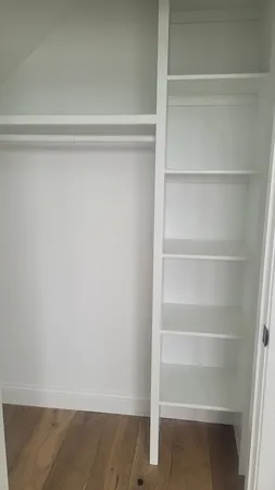 a view of walk in closet with empty racks