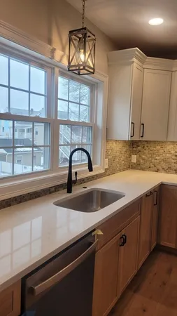 a kitchen with stainless steel appliances granite countertop a sink a stove and cabinets