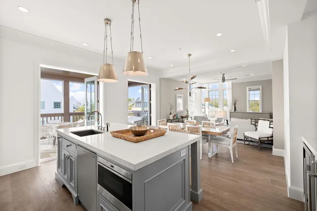 a kitchen with a stove a sink a kitchen island with chairs and cabinets