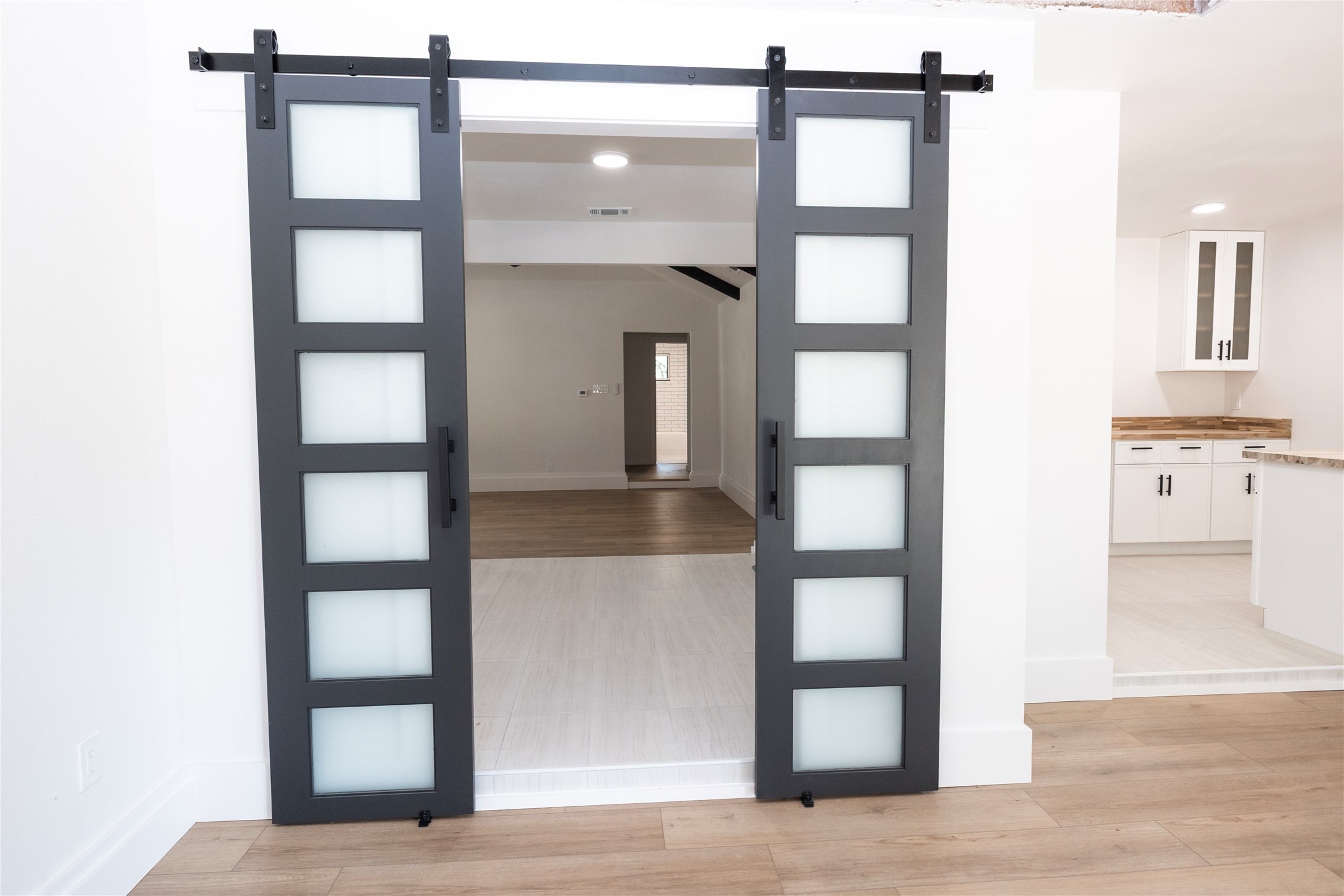 205 Bello Circle Georgetown, TX 78628 - Photo 16 of 36 Sliding barn doors with frosted glass panels open to reveal an adjacent room.