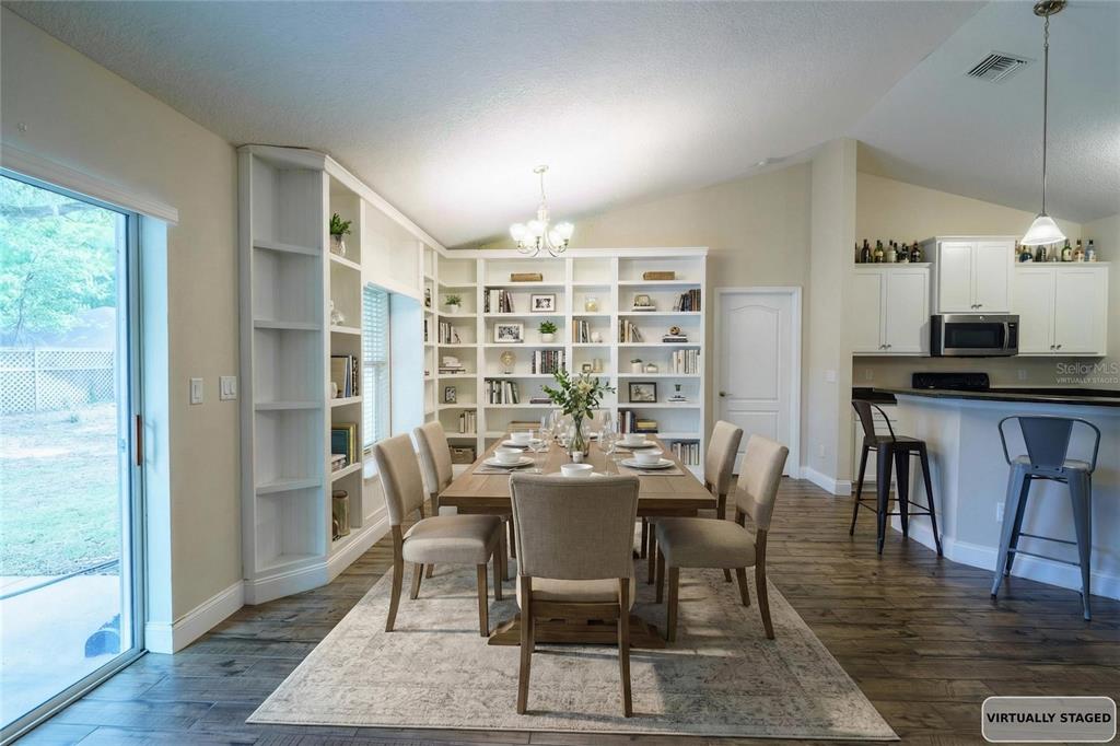 5273 Southwest 96th Place Ocala, FL 34476 - Photo 13 of 55 a view of a dining room with furniture and wooden floor