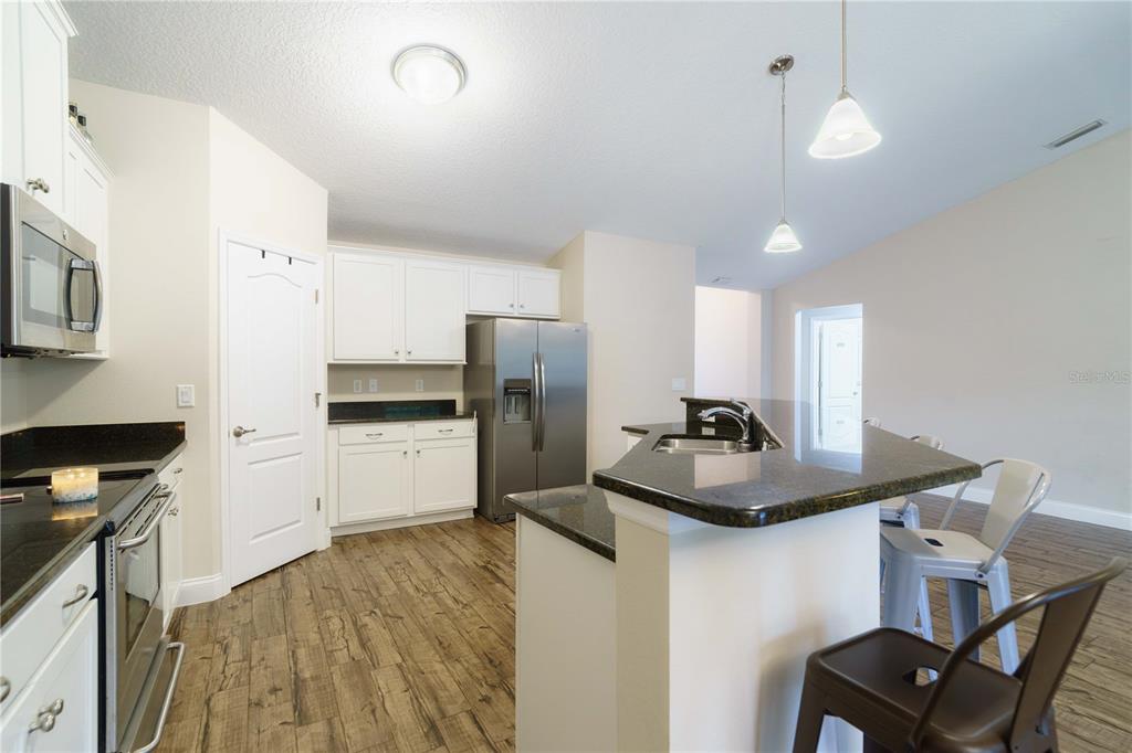 5273 Southwest 96th Place Ocala, FL 34476 - Photo 18 of 55 a kitchen with stainless steel appliances granite countertop a sink refrigerator and microwave