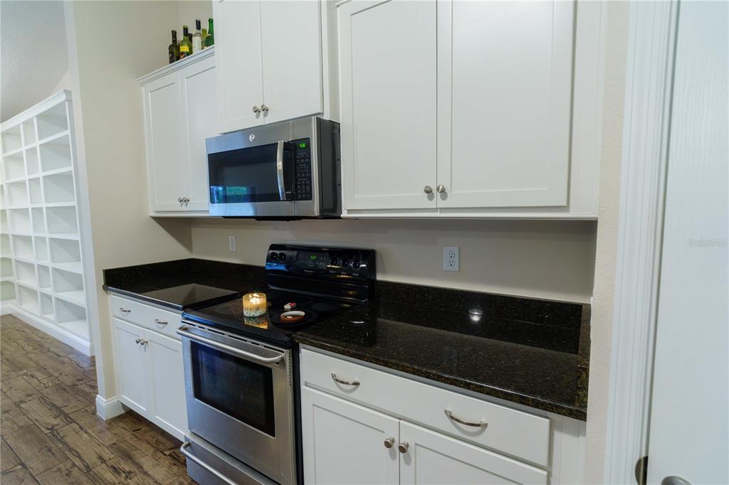 5273 Southwest 96th Place Ocala, FL 34476 - Photo 19 of 55 a kitchen with granite countertop white cabinets and stainless steel appliances