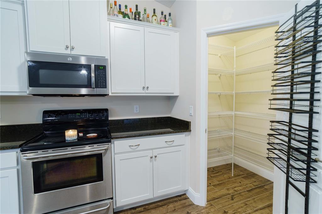 5273 Southwest 96th Place Ocala, FL 34476 - Photo 20 of 55 a kitchen with granite countertop white cabinets and black appliances