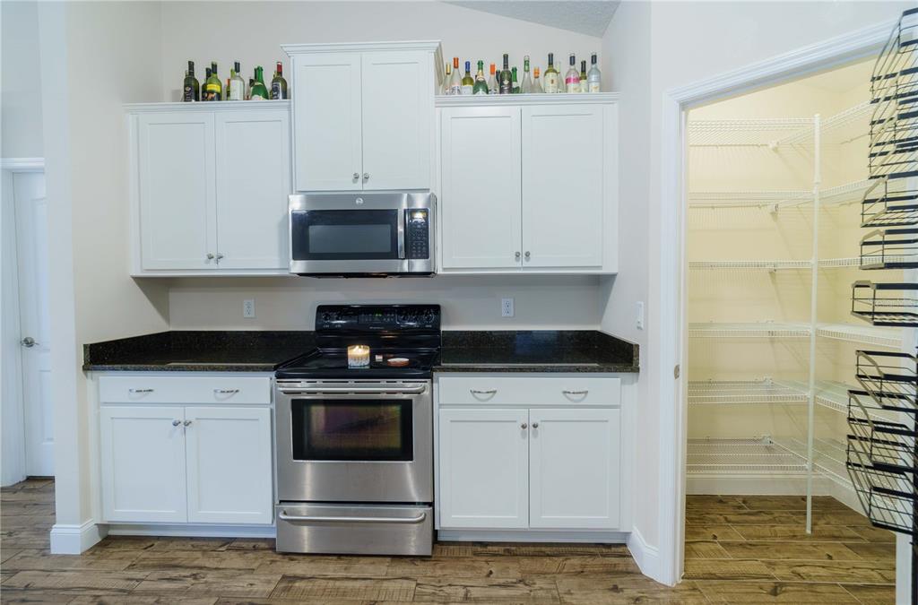 5273 Southwest 96th Place Ocala, FL 34476 - Photo 21 of 55 a kitchen with granite countertop white cabinets and stainless steel appliances