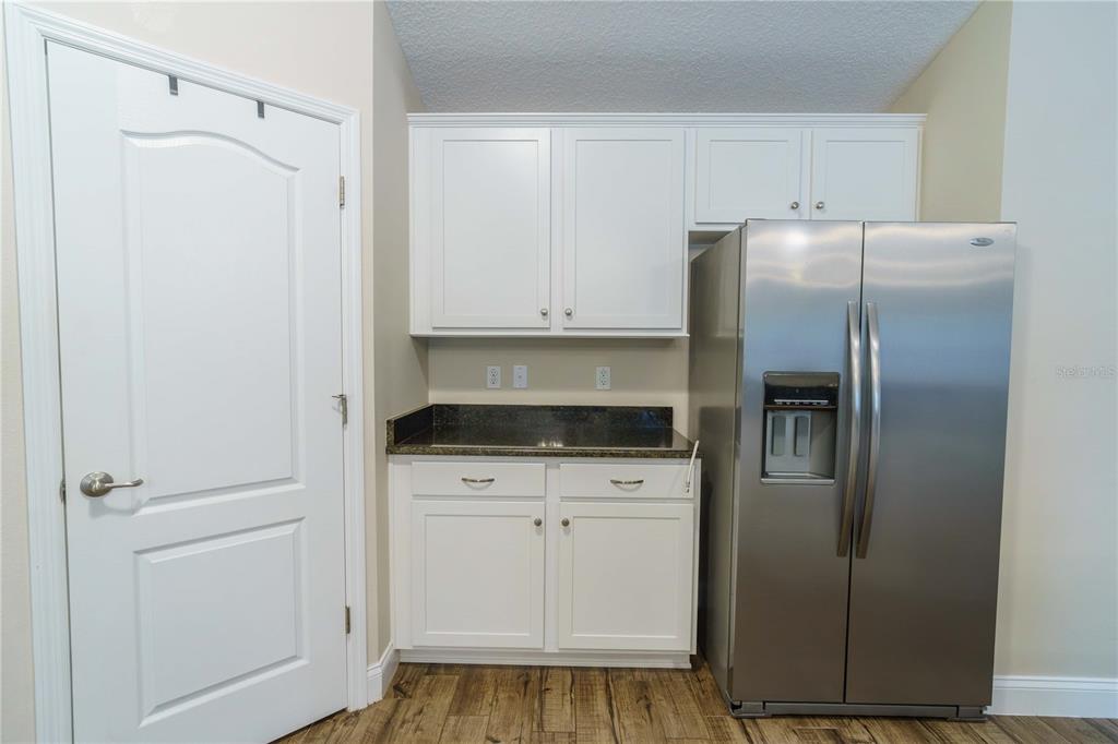 5273 Southwest 96th Place Ocala, FL 34476 - Photo 23 of 55 a kitchen with white cabinets and stainless steel appliances
