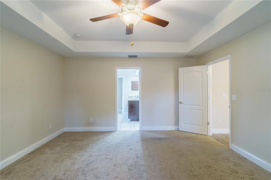 5273 Southwest 96th Place Ocala, FL 34476 - Photo 29 of 55 an empty room with chandelier fan and windows