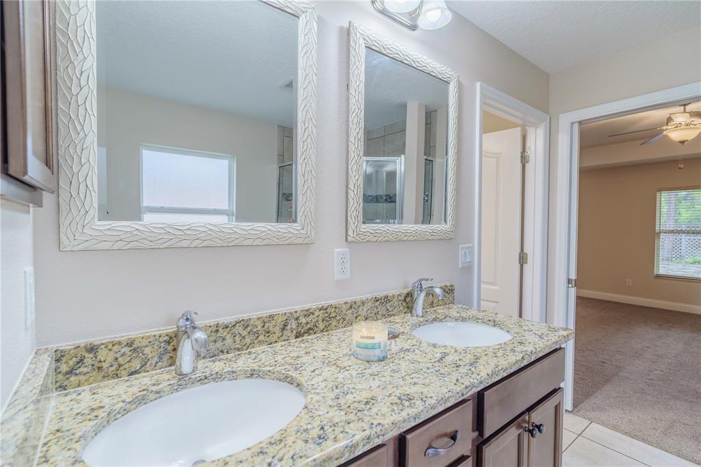 5273 Southwest 96th Place Ocala, FL 34476 - Photo 37 of 55 a bathroom with a granite countertop sink and a mirror
