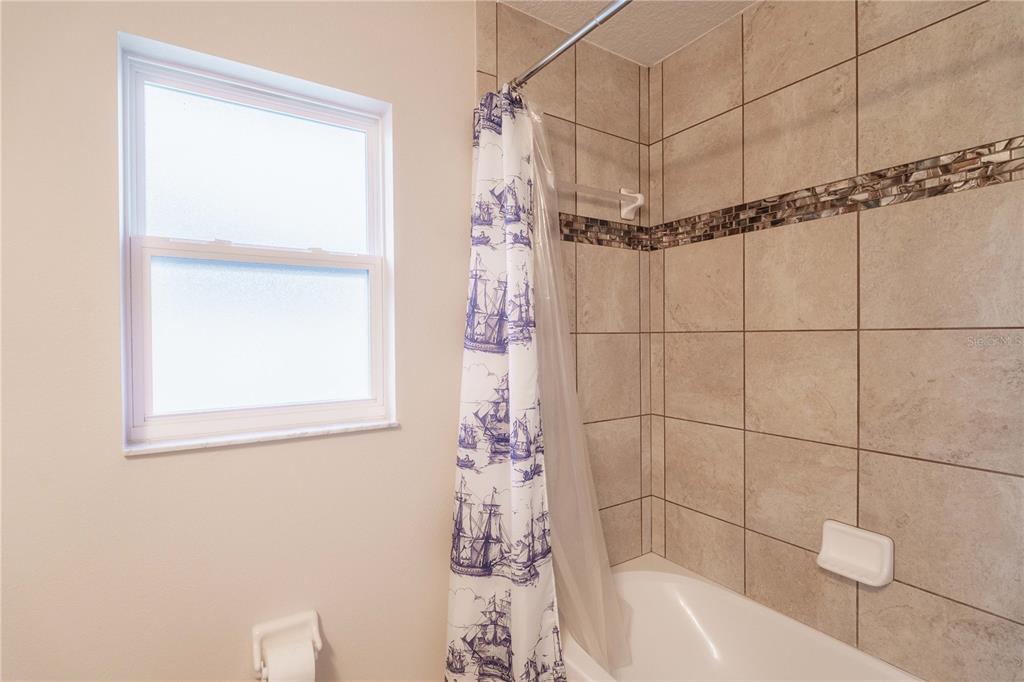 5273 Southwest 96th Place Ocala, FL 34476 - Photo 47 of 55 a bathroom with a shower curtain and a bathtub