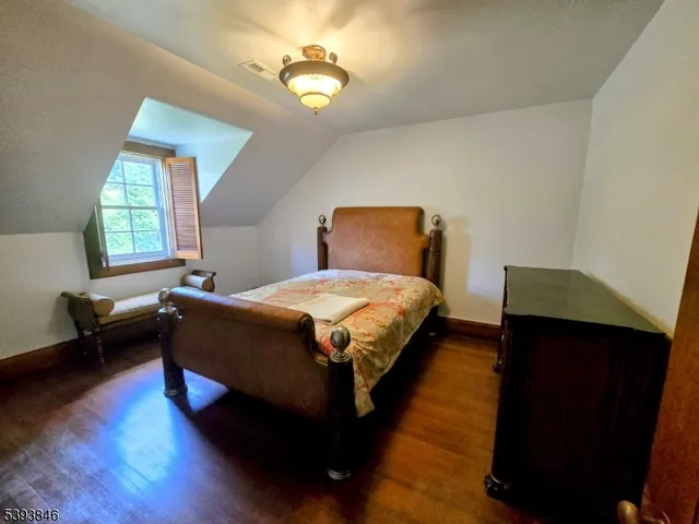 a spacious bedroom with a bed and a dresser next to a window