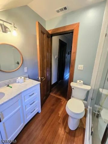 a bathroom with a granite countertop toilet sink and mirror
