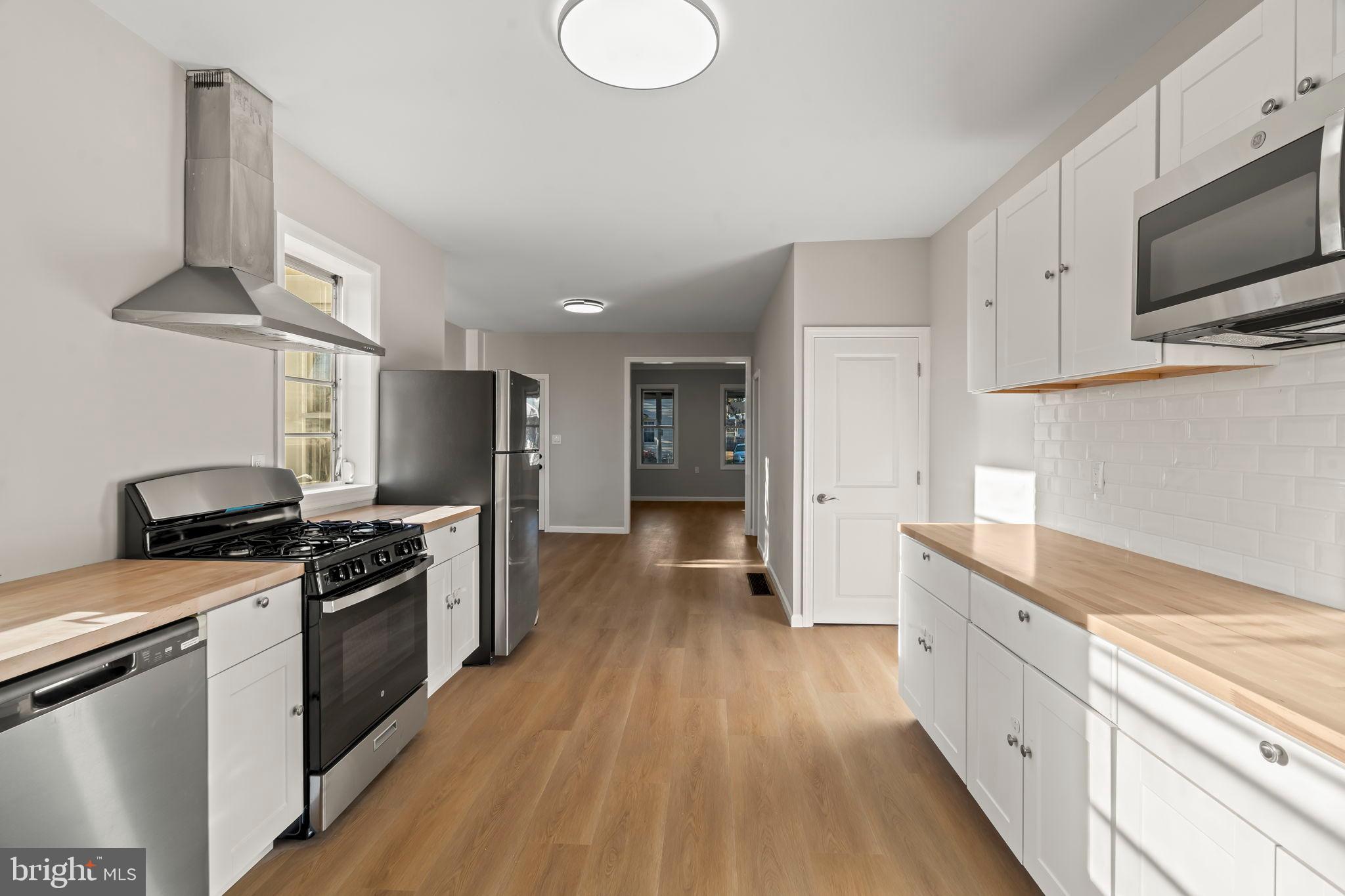606 Spruce Street Delanco, NJ 08075 - Photo 13 of 29 a kitchen with stainless steel appliances a stove top oven a sink a refrigerator white cabinets and wooden floor