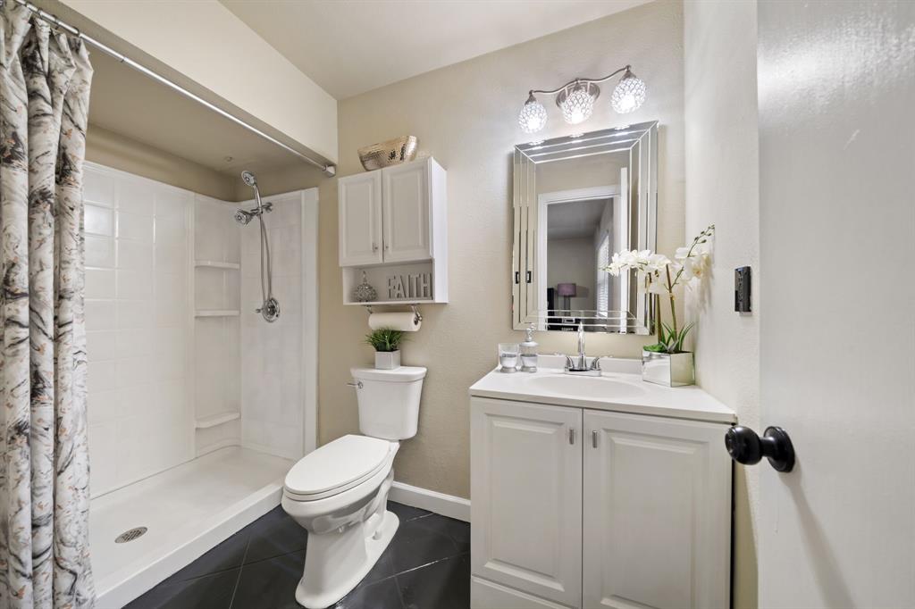 622 Roaming Rd Drive Allen, TX 75002 - Photo 18 of 27 a bathroom with a sink toilet a mirror and shower