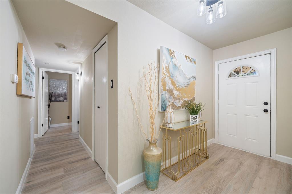 622 Roaming Rd Drive Allen, TX 75002 - Photo 4 of 27 a view of a hallway with a livingroom and a chandelier fan wooden floor and windows