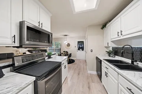 a kitchen with stainless steel appliances a stove sink microwave and cabinets