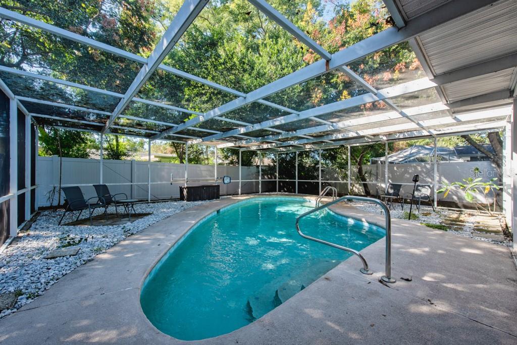 1877 Dawn Drive Clearwater, FL 33763 - Photo 24 of 36 a view of a backyard with table and chairs with wooden fence and plants