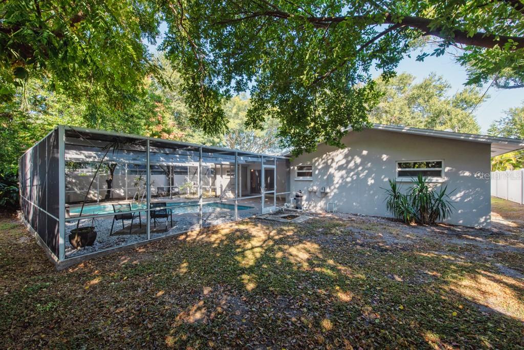 1877 Dawn Drive Clearwater, FL 33763 - Photo 27 of 36 a view of a backyard with table and chairs under an umbrella