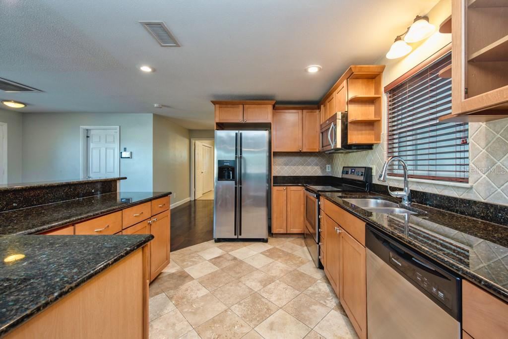 1877 Dawn Drive Clearwater, FL 33763 - Photo 10 of 36 a large kitchen with stainless steel appliances granite countertop a sink and a stove