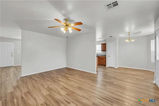 wooden floor in an empty room with a kitchen