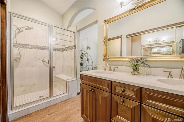 a bathroom with a granite countertop shower sink and mirror