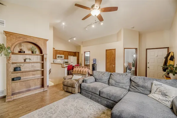a living room with furniture and a wooden floor