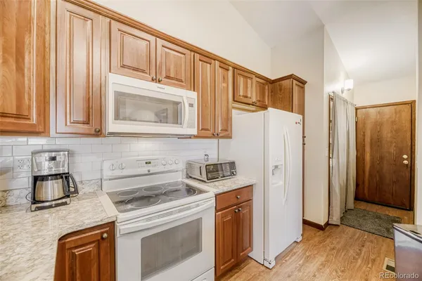 a kitchen with stainless steel appliances granite countertop a refrigerator sink and stove