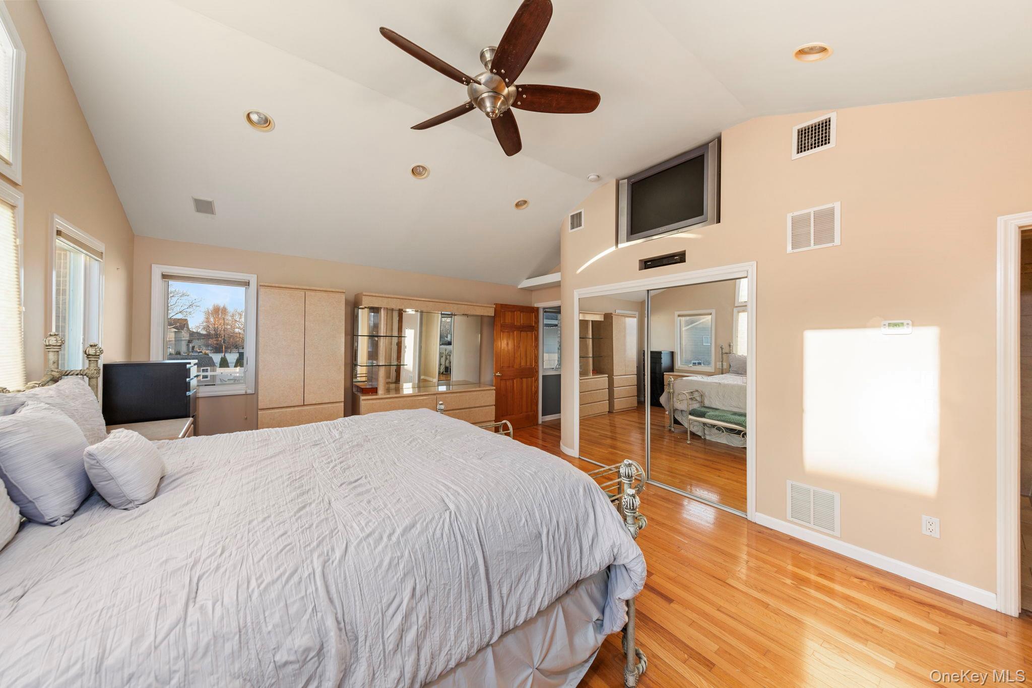 2770 Mandalay Beach Road Wantagh, NY 11793 - Photo 14 of 27 a spacious bedroom with a large bed and a chandelier