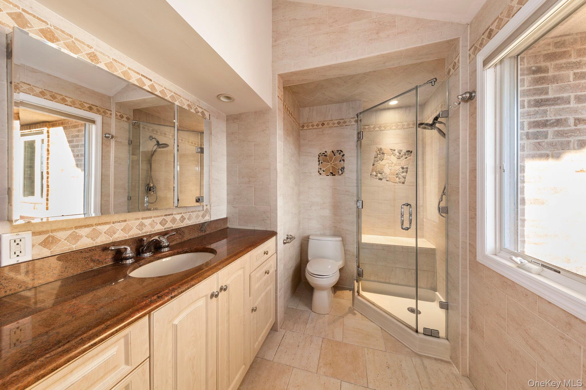 2770 Mandalay Beach Road Wantagh, NY 11793 - Photo 15 of 27 a spacious bathroom with a granite countertop sink a toilet a mirror and a shower