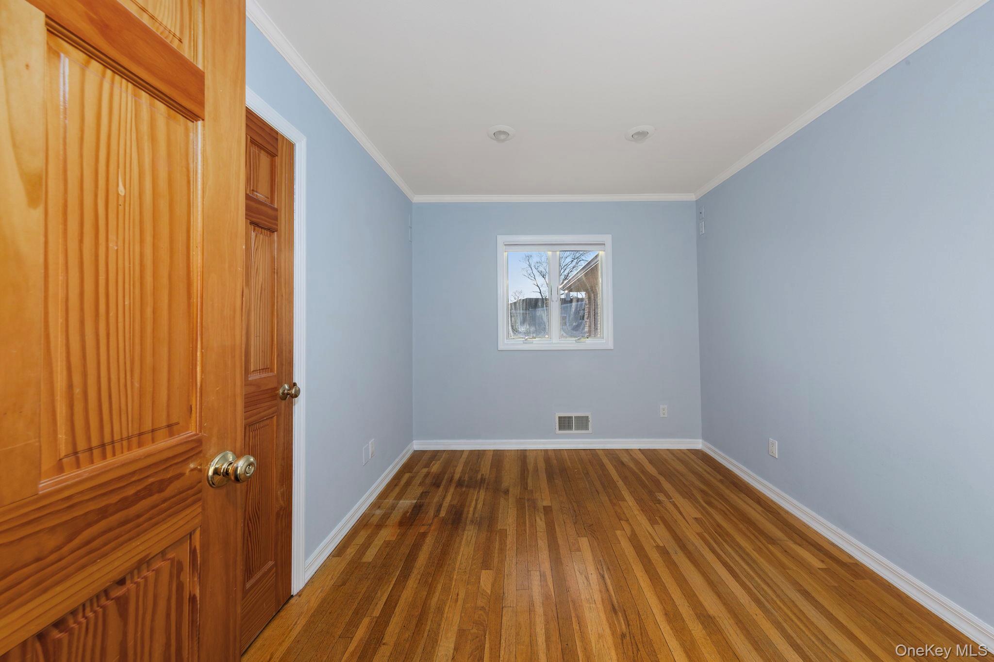 2770 Mandalay Beach Road Wantagh, NY 11793 - Photo 17 of 27 a view of a room with wooden floor and small window