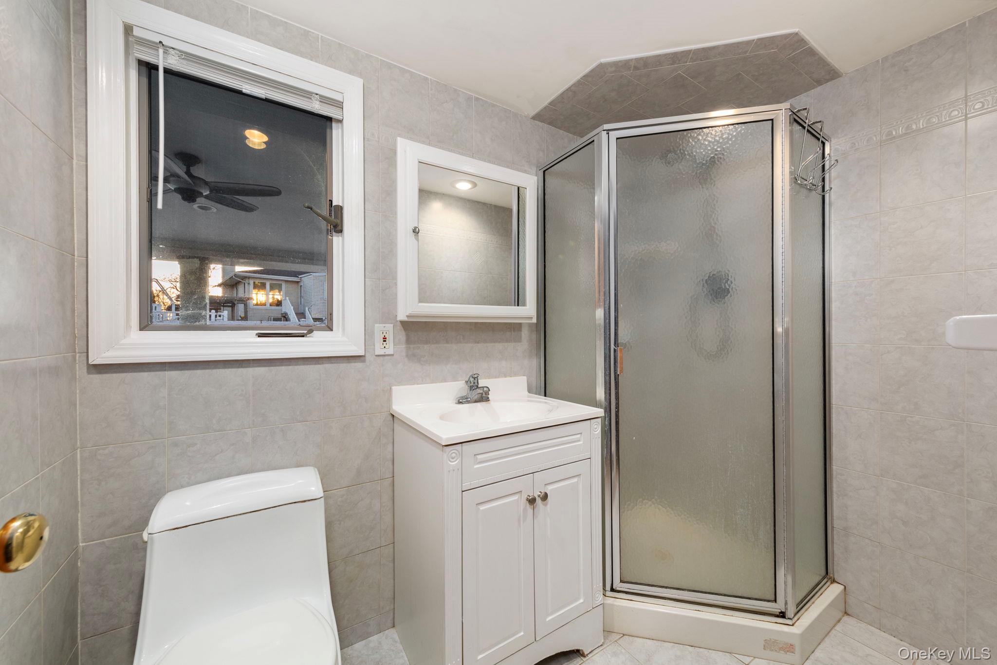 2770 Mandalay Beach Road Wantagh, NY 11793 - Photo 23 of 27 a bathroom with a sink a toilet and shower