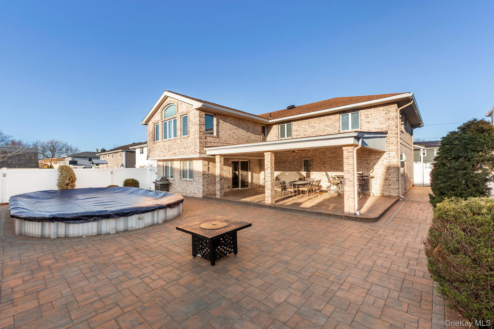 2770 Mandalay Beach Road Wantagh, NY 11793 - Photo 24 of 27 a front view of a house with outdoor seating and a patio