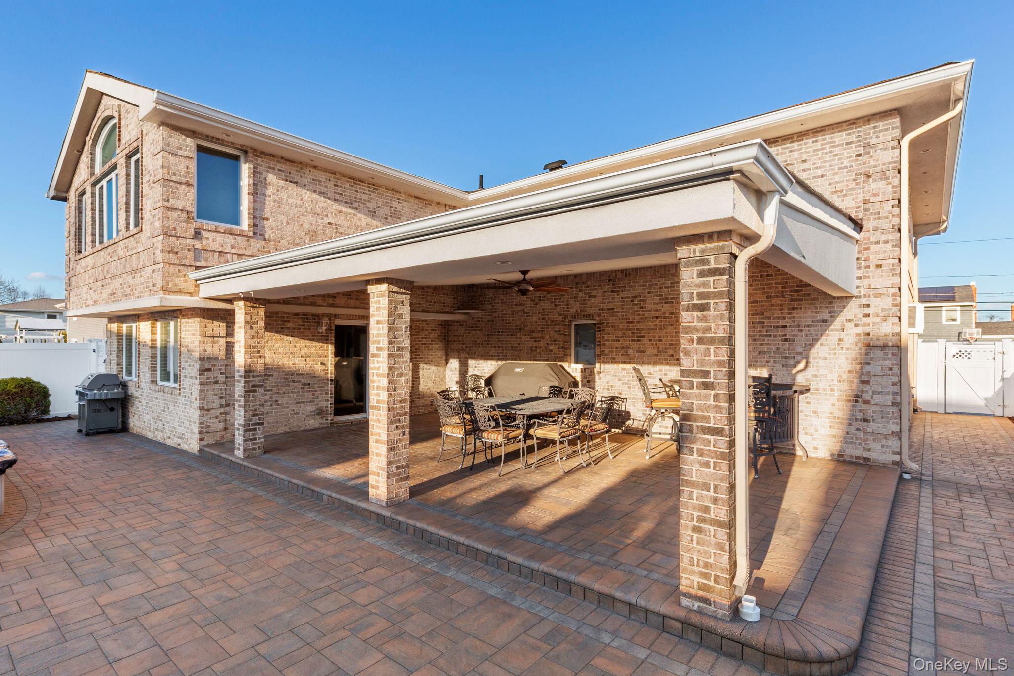 2770 Mandalay Beach Road Wantagh, NY 11793 - Photo 25 of 27 a view of a patio with table and chairs next to a yard
