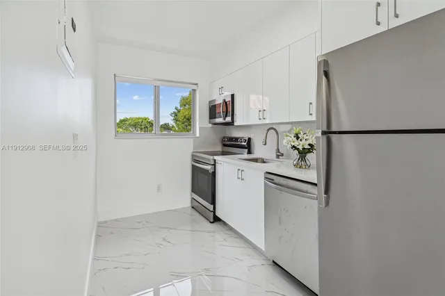 a kitchen with a refrigerator sink stove and cabinets