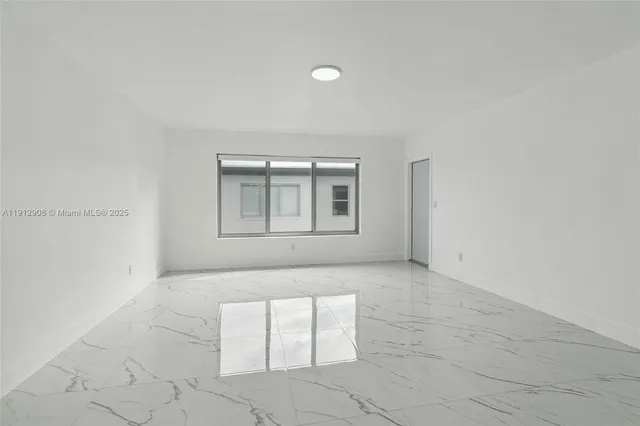 an empty room with windows and entrance