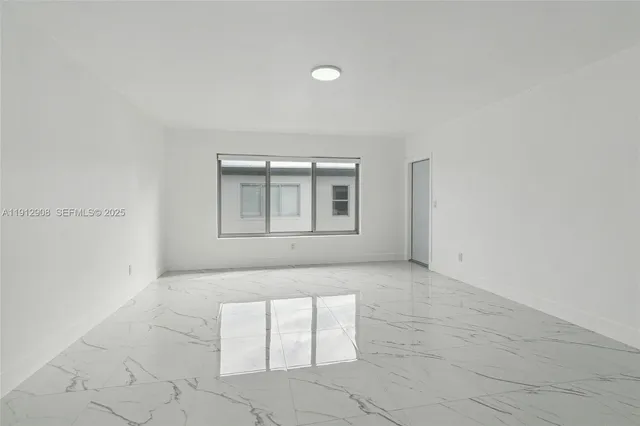 an empty room with windows and entrance