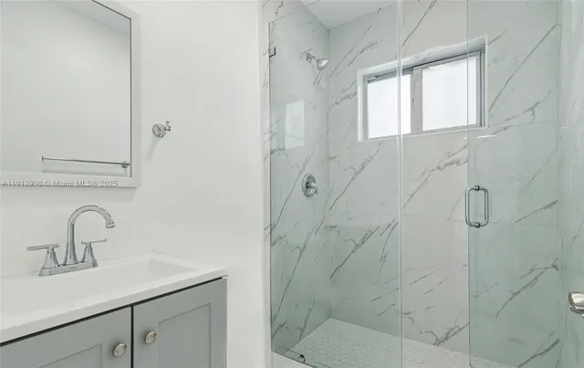 a bathroom with a shower sink and vanity