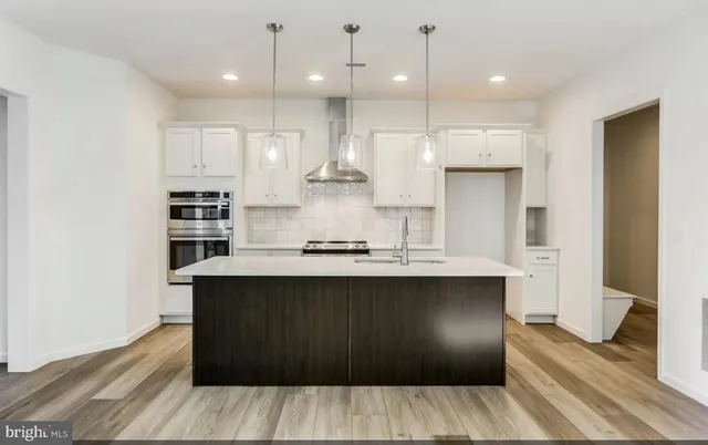 a kitchen with kitchen island wooden cabinets and refrigerator