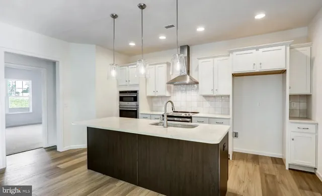 a kitchen with kitchen island a stove a refrigerator and a sink