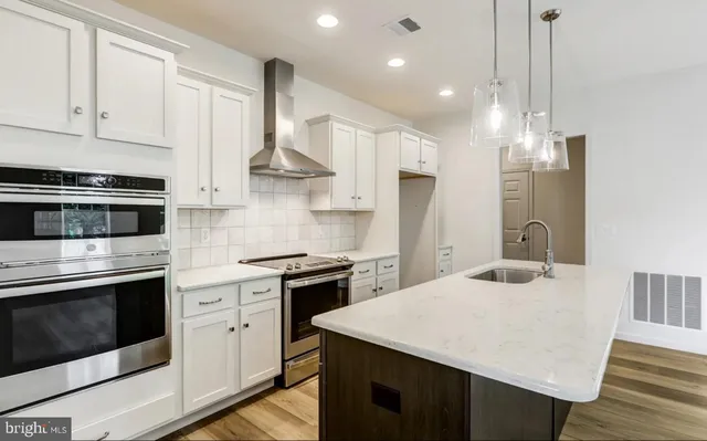 a kitchen with kitchen island a stove a sink a microwave and wooden cabinets