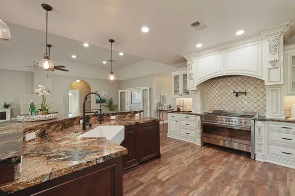 a large kitchen with stainless steel appliances granite countertop a stove and a sink