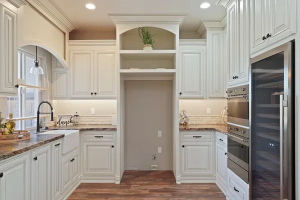 a kitchen with white cabinets and appliances