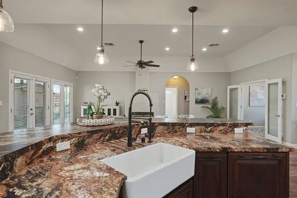 a large kitchen with a sink and dishwasher a stove with wooden floor
