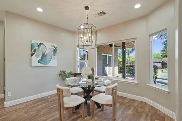 a view of a dining room with furniture wooden floor and a chandelier