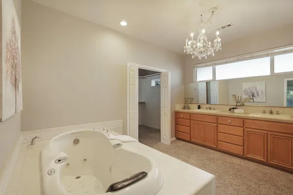 a spacious bathroom with a tub sink and mirror