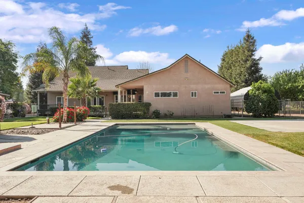 a view of a house with swimming pool and sitting area