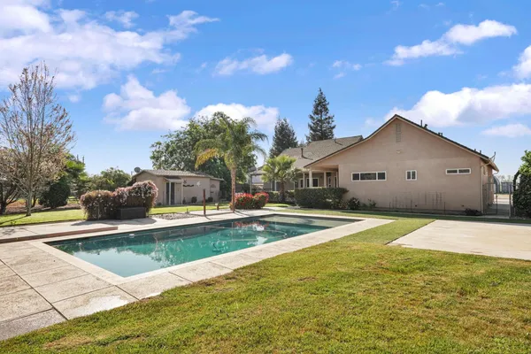 a view of a house with swimming pool and sitting area