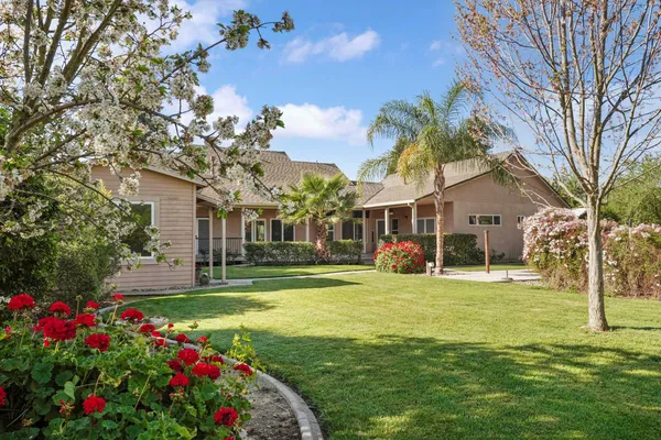 a view of a house with a big yard and garden