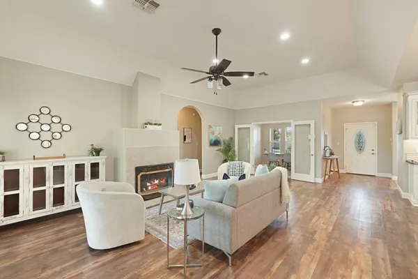 a living room with furniture a fireplace and a chandelier