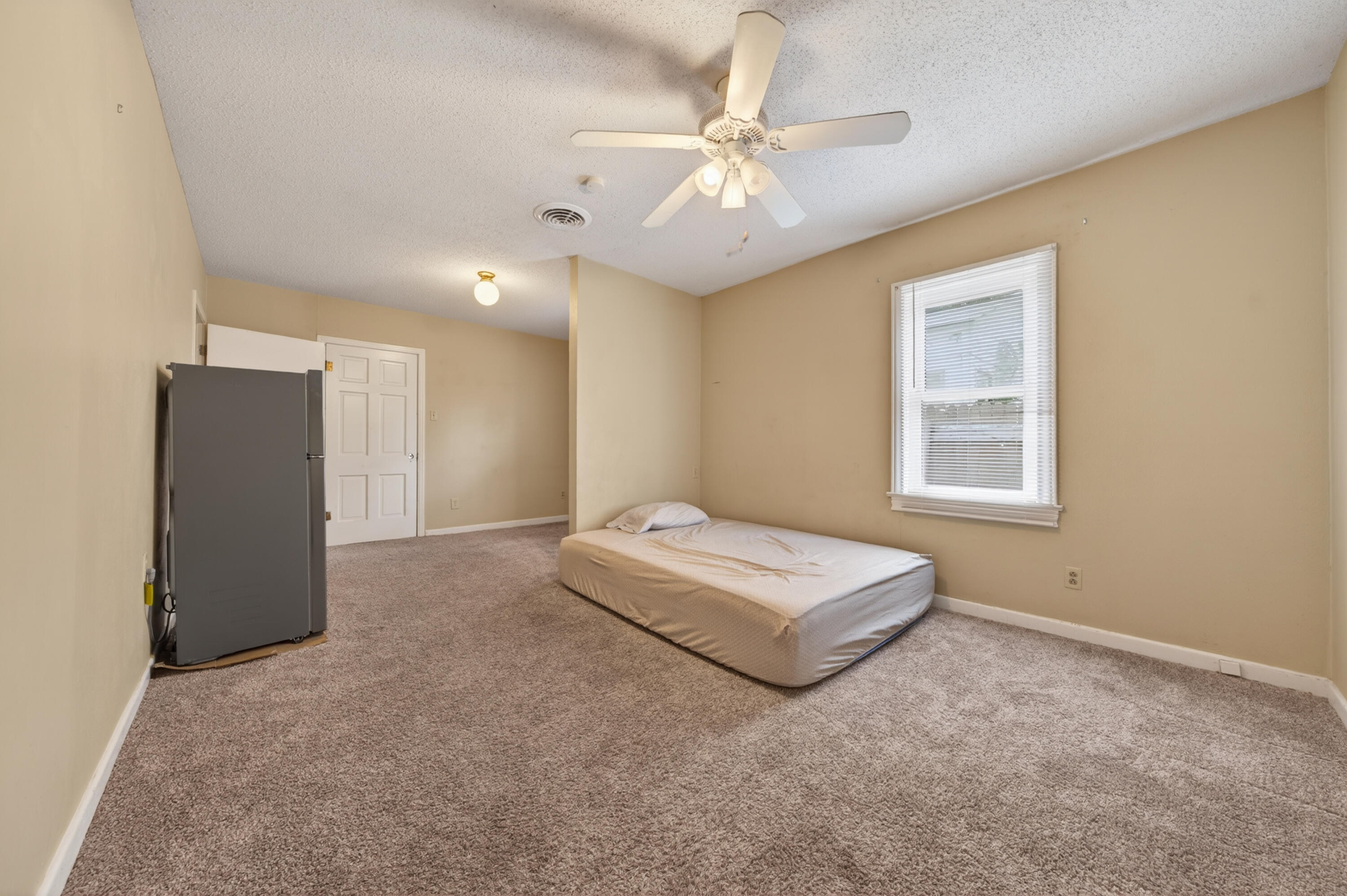 2212 22nd Street Lubbock, TX 79411 - Photo 9 of 14 a spacious bedroom with a bed and a chandelier